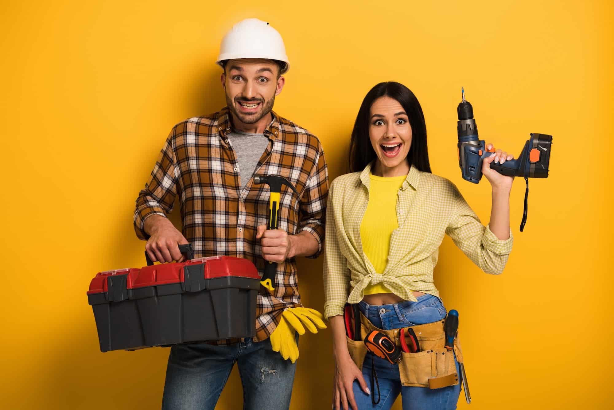 excited-handywoman-and-handyman-holding-toolbox-and-electric-drill-on-yellow.jpg